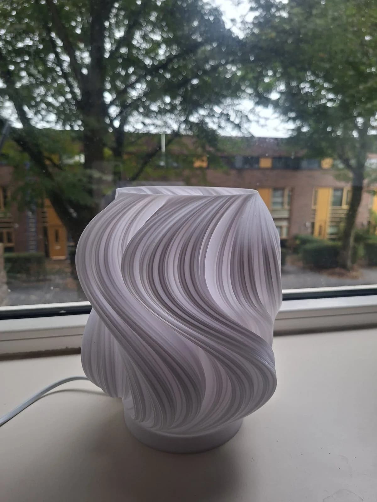 Finished white wave lamp on a windowsill.