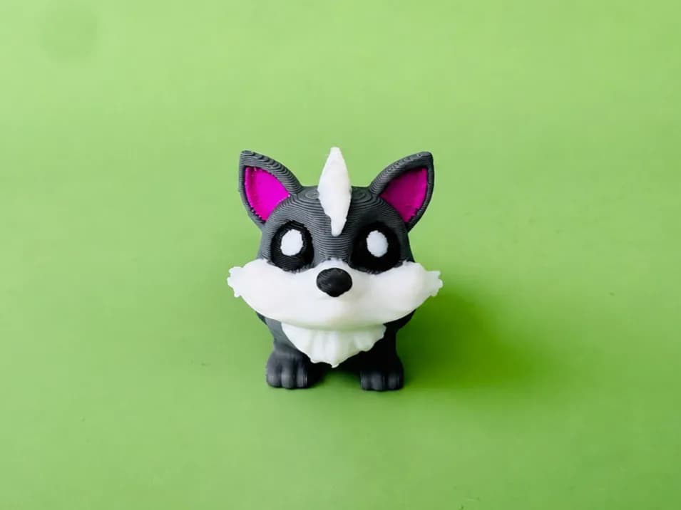 Beweegbare wolf-sleutelhanger van voren: grijze wolf met witte snuit en borst en roze oren, op een groene achtergrond