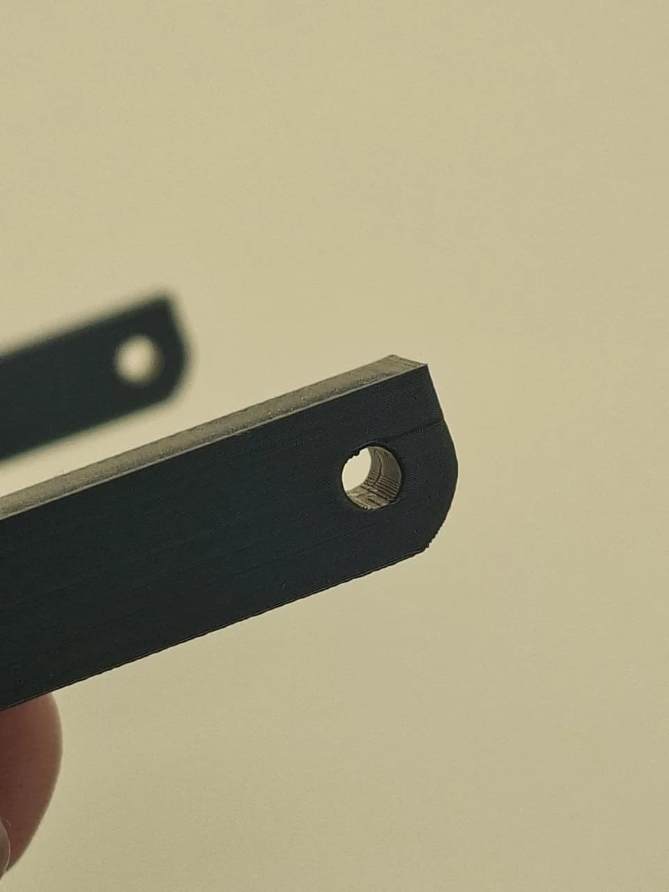 Angled inspection of version 3 showing the outer wall, layer lines and hole.
