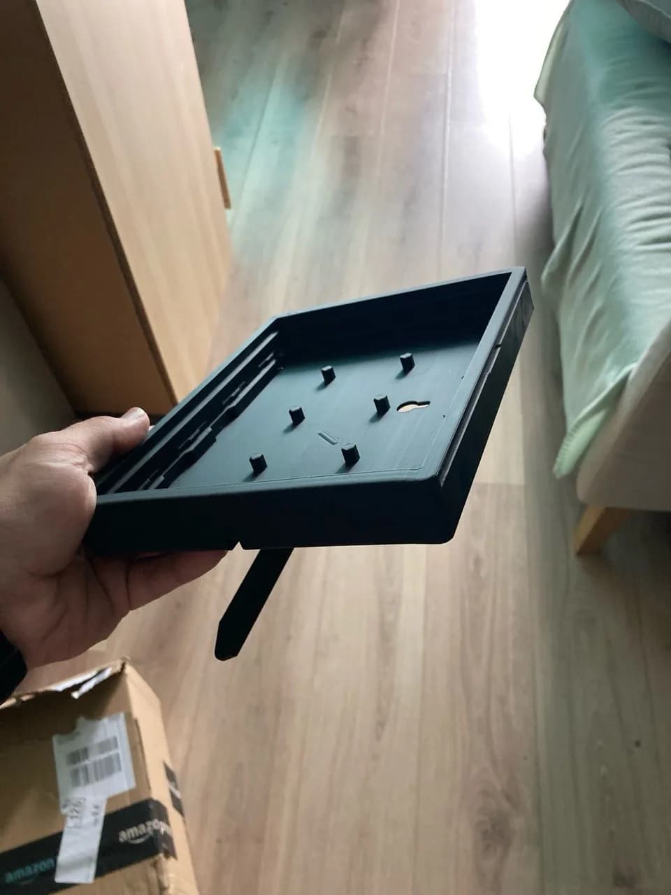 3D-printed enclosure with cut-outs and clip joints, held in one hand.