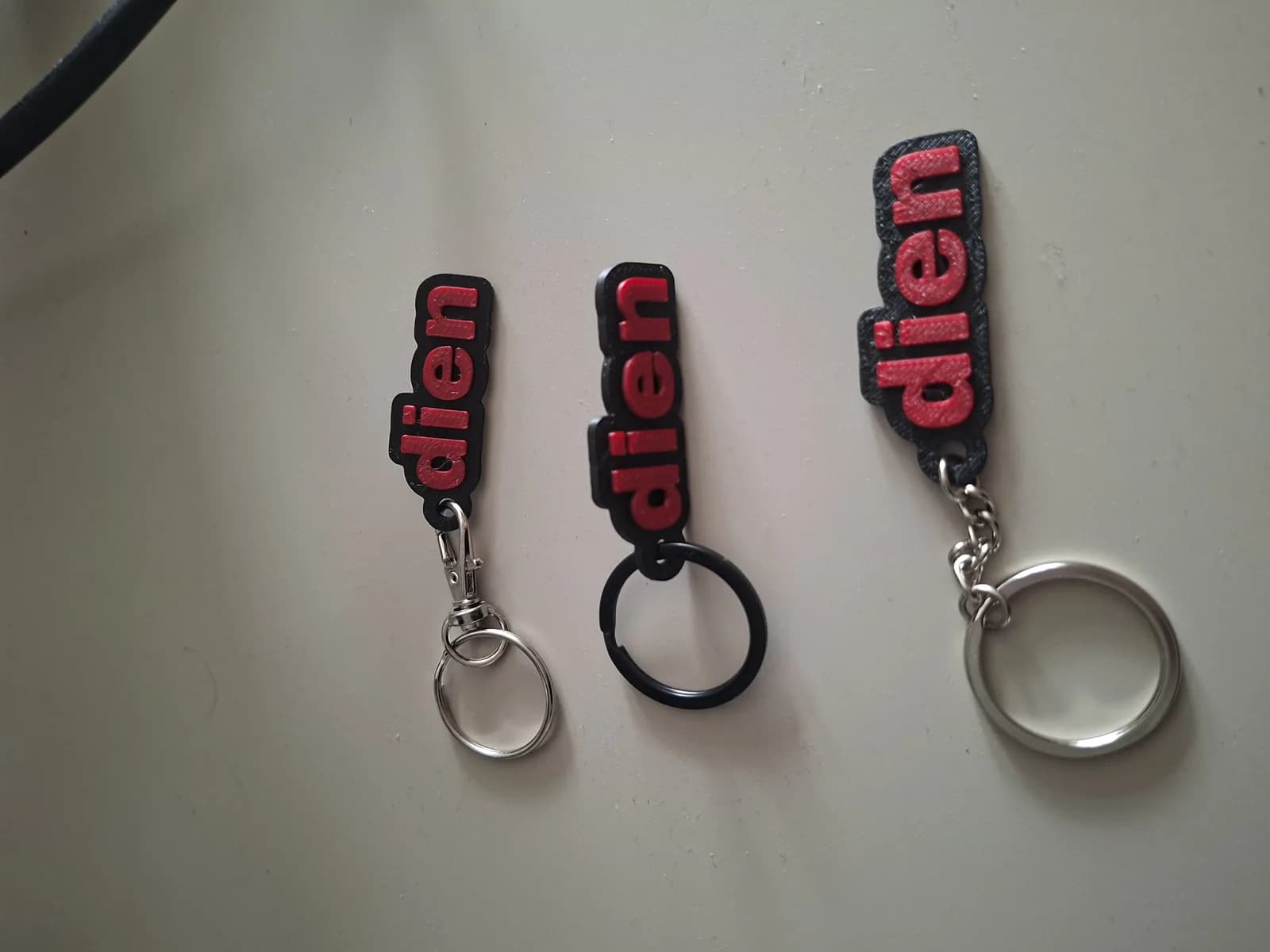 Three keychain test prints with lobster clasp, black split ring and chain