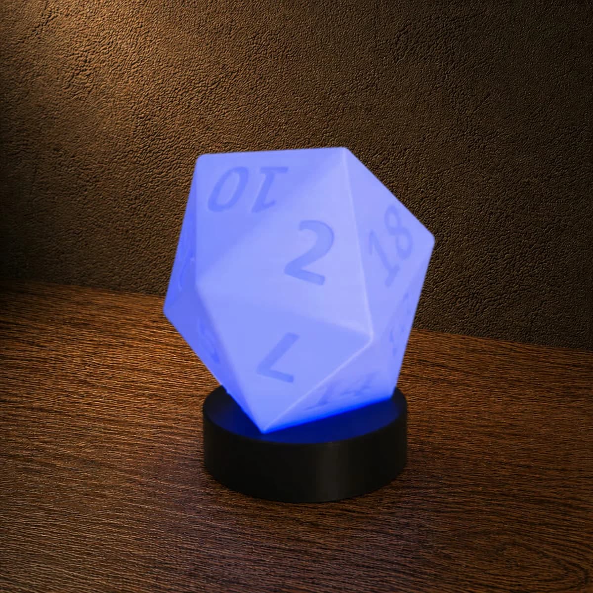 Voorbeeldfoto van de D20-lamp door FantaZ: een blauw verlichte, genummerde twintigvlakkige kap op een zwarte ronde voet