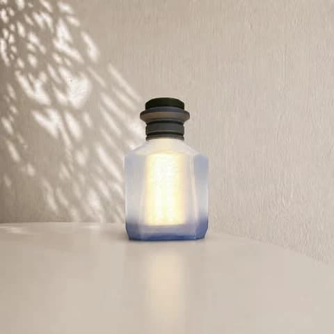 Makeruitvoering van de Gaming Potion-lamp: verlichte hoekige fles met blauwe onderrand en donkere hals; lichtmodule en kleuruitvoering afzonderlijk af te spreken