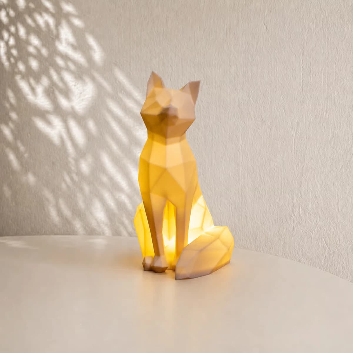 Makeruitvoering van de Geometric Fox-lamp: verlichte geometrische vos met puntige oren en grote staart op een kast; lichtmodule afzonderlijk af te spreken