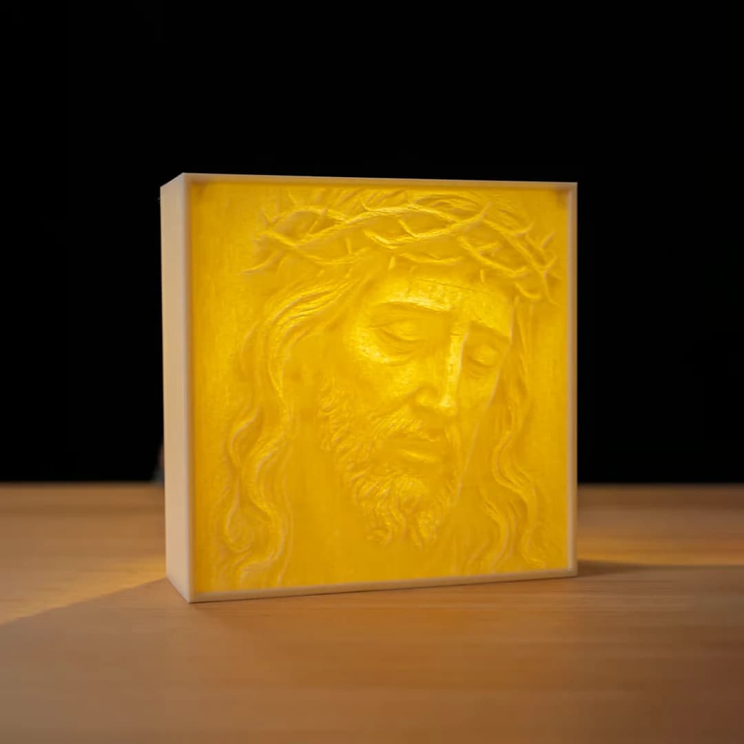 Makerbeeld van de Jesus Light Box op een tafel, met warm verlicht Jezusportret en lichte rand tegen een donkere achtergrond