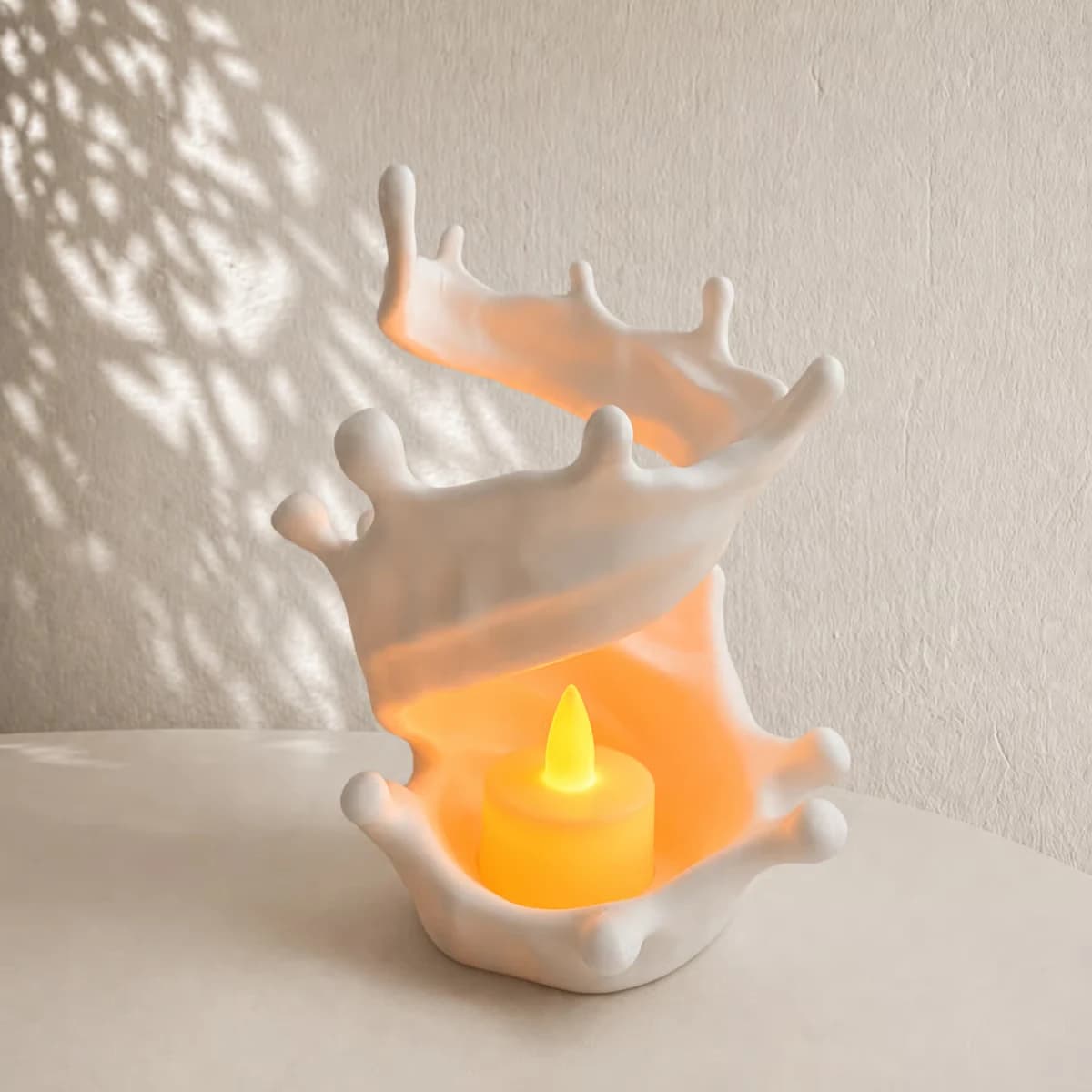 Makerbeeld van de witte Milk Splash LED-kaarshouder met een afzonderlijk warm verlicht LED-lichtje in de ronde uitsparing